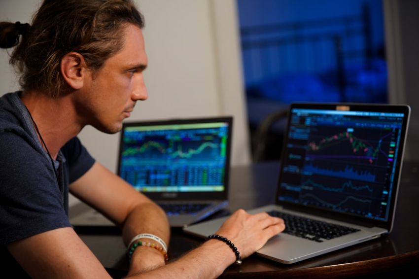 Stock Trading - man sitting in front of the MacBook Pro