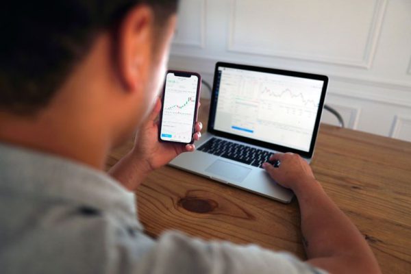 Stock Trading - man in gray hoodie holding black smartphone