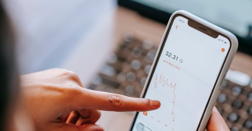 Stock Trading - Crop dealer analyzing graphic while using application on smartphone screen
