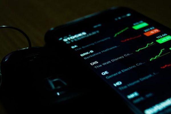 Stock Trading - smartphone on brown wooden surface