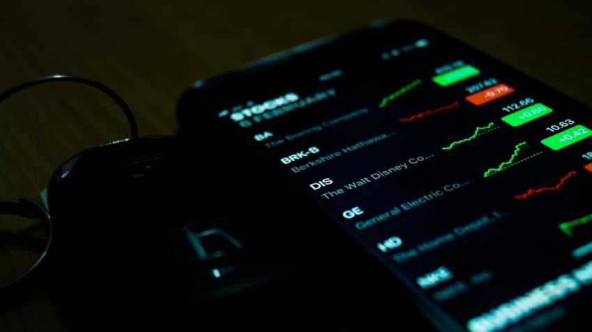 Stock Trading - smartphone on brown wooden surface