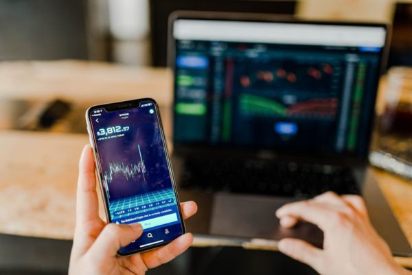 Stock Trading - person using phone and laptop computer