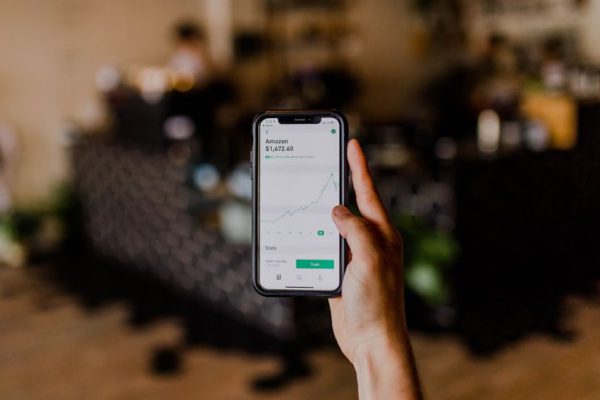 Stock Trading - person holding black iPhone displaying stock exchange