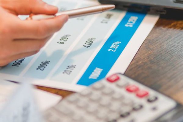 Interest Rates - A Close-Up Shot of an Agent Pointing Rates with a Ballpen