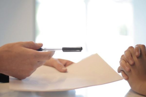 How Do Trade Policies Influence Economies Policies - Crop businessman giving contract to woman to sign