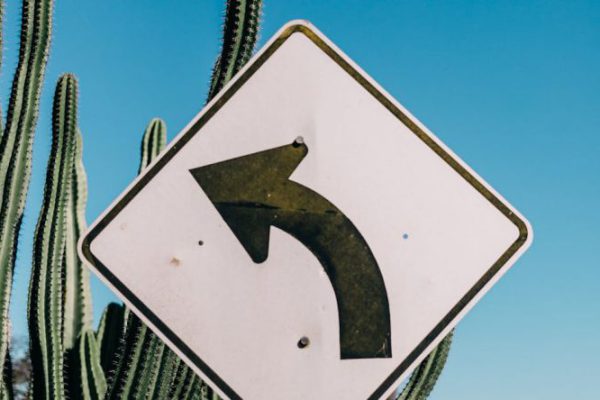 How Do Regulations Impact Tech Companies Regulations - Roadway sign in desert land
