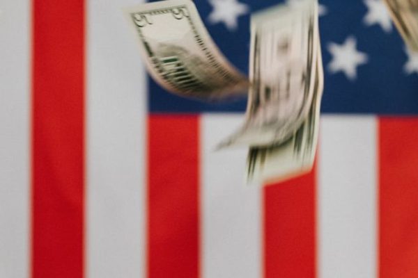 Inflation - National flag of United States of America on background and dollars falling down