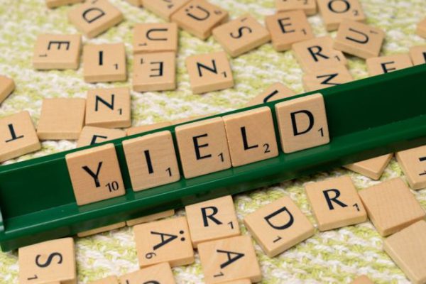 Dividends - A scrabble board with the word yield written on it