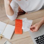 Inflation - Woman Sitting Behind the Desk and Looking at Receipts 
