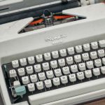 Swaps - Green and Gray Typewriter on Red Table