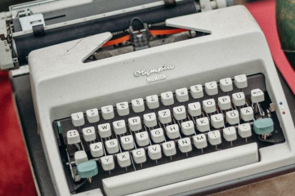 Swaps - Green and Gray Typewriter on Red Table